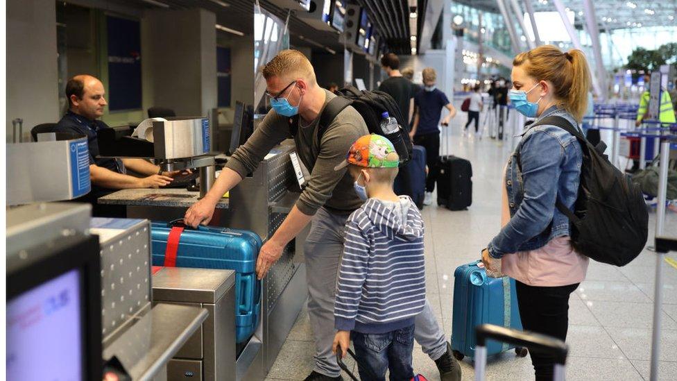 Tourists wait to check in for a Tui flight at Dusseldorf Airport