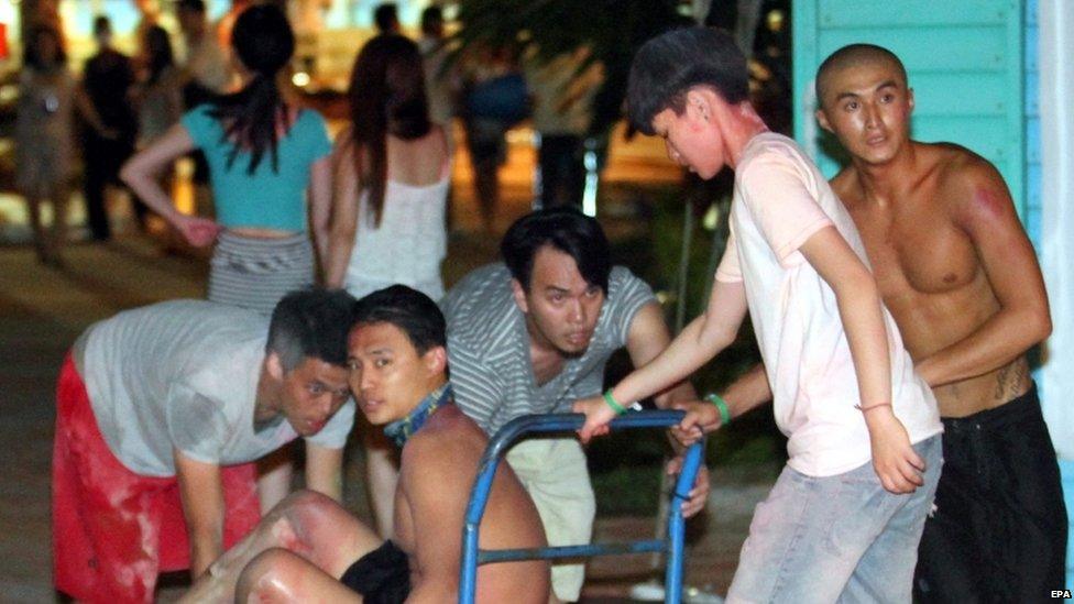 Taiwanese push a young man suffering from burns to his legs to an ambulance at the Formosa Fun Coast park in the Bali District of New Taipei City, northern Taiwan, 27 June