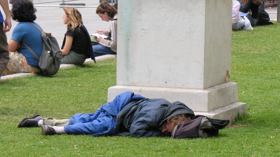 A homeless man asleep in a park