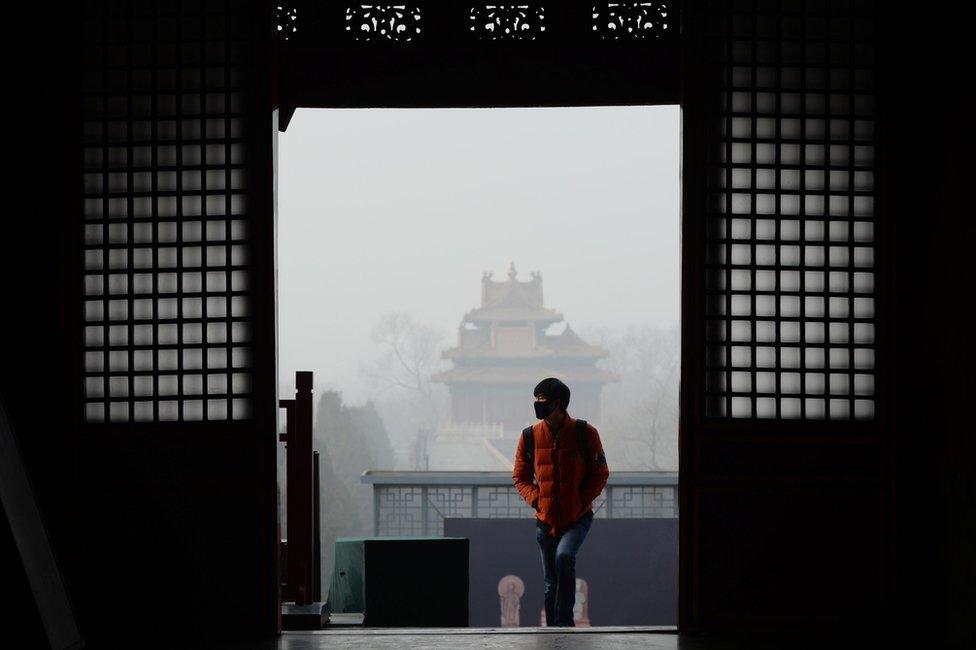 A man wearing a mask visits the Forbidden City in Beijing on 21 December 2016.