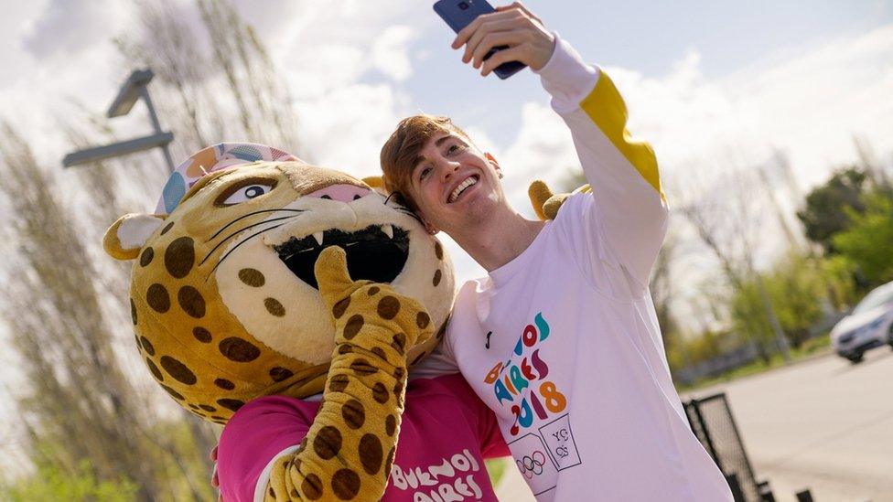 A picture of the mascot with a fan, taken on the torch's tour around the country.