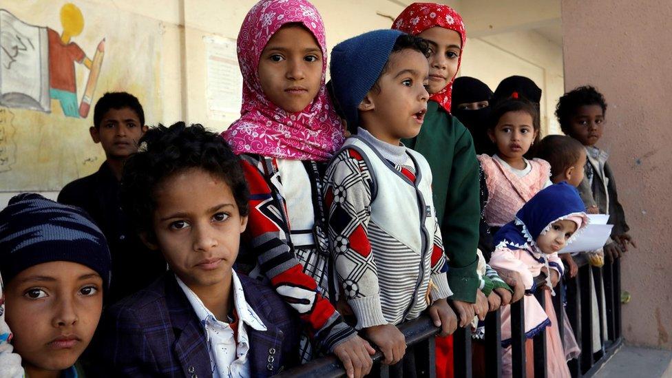 Children wait for food aid provided by a local humanitarian agency in Sanaa, Yemen (1 December 2021)