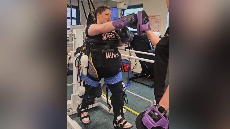 Sophie Shuttleworth practices boxing while using the exoskeleton 