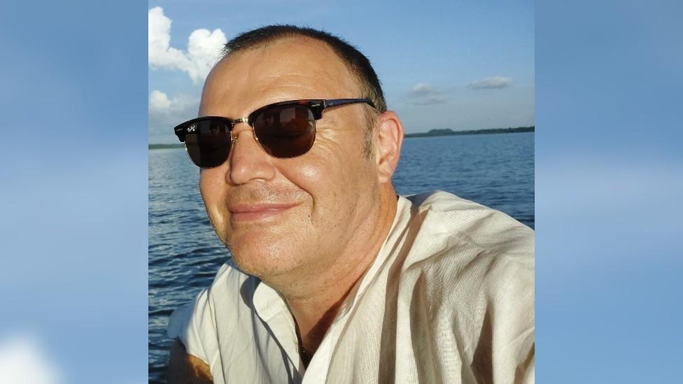 Justin Edhouse smiling at the camera wearing sunglasses