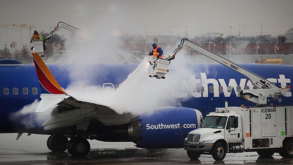 Workers de-ice a Southwest Airline's aircraft at Midway Airport.