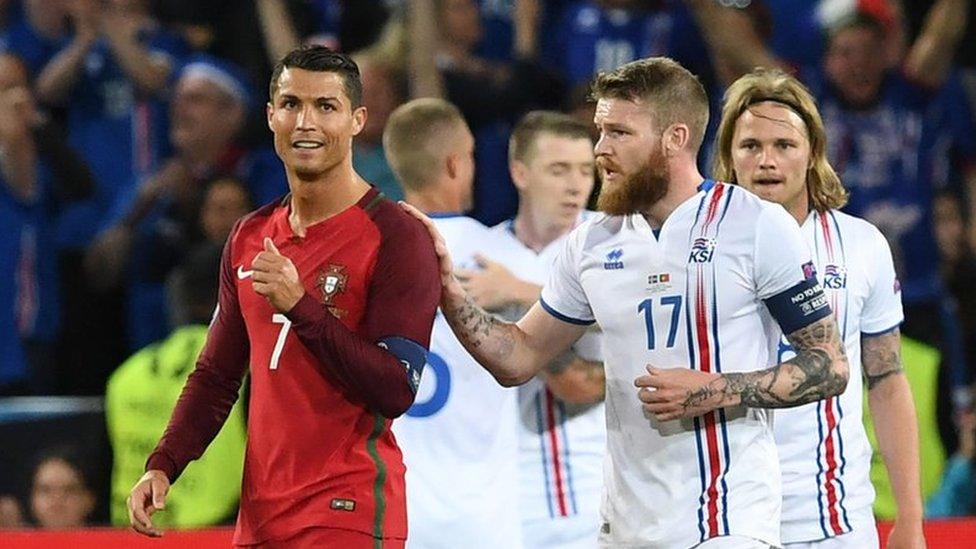 Iceland"s midfielder Aron Gunnarsson (R) taps Portugal"s forward Cristiano Ronaldo (L) on the shoulder