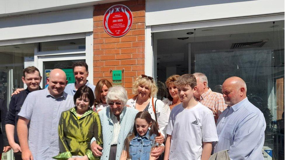 Mr Ogden's family in front of the red plaque