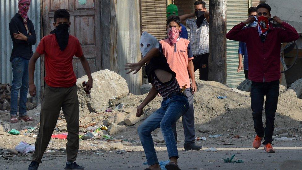 Kashmiri protesters through stones towards Indian government forces.