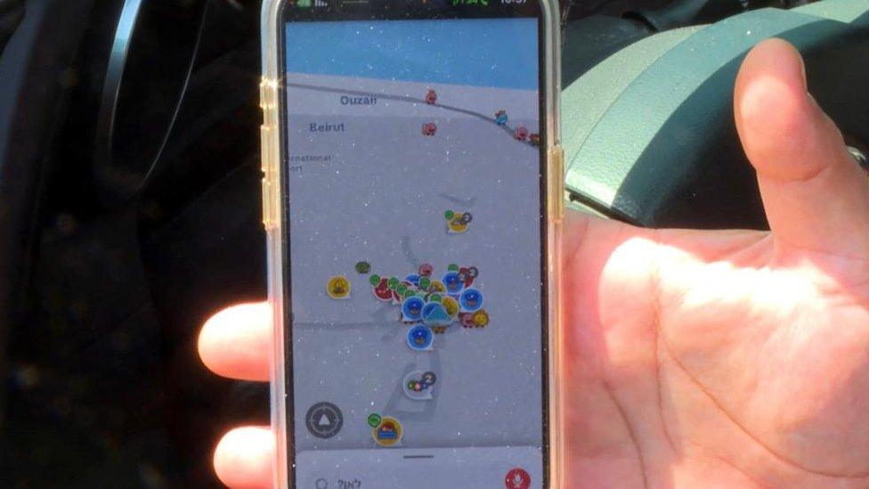 A hand holding a mobile phone showing a navigation app