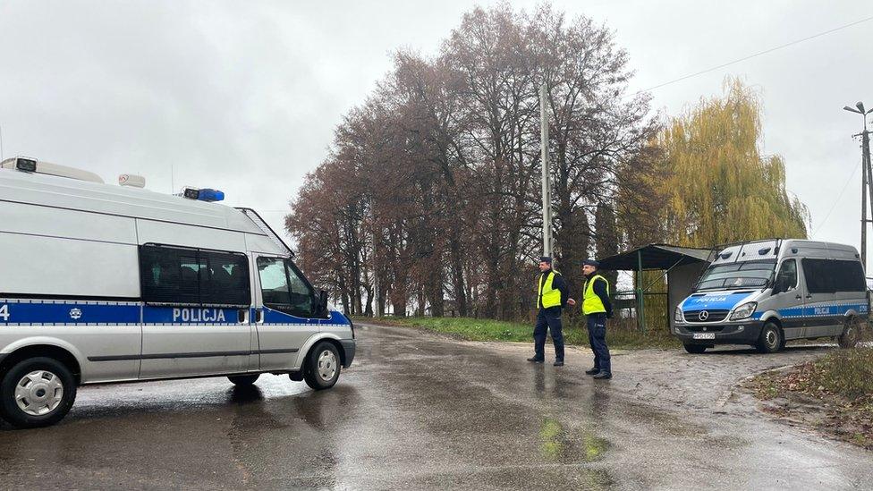 Police officers walk next to a police vehicle at a blockade after an explosion in Przewodow, a village in eastern Poland near the border with Ukraine, November 16, 2022. R