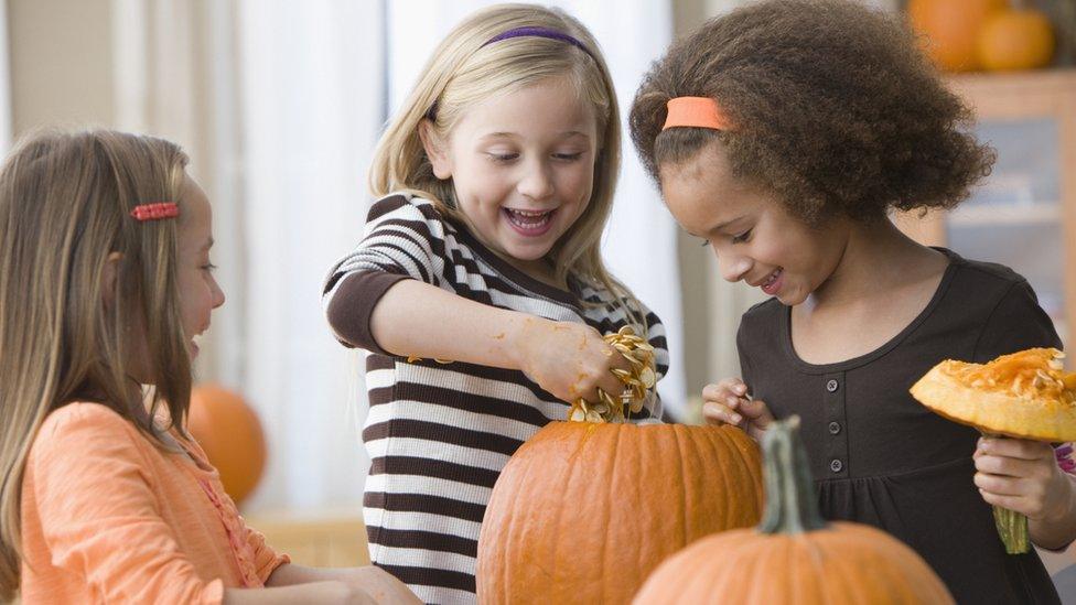 Kids carving pumpkins
