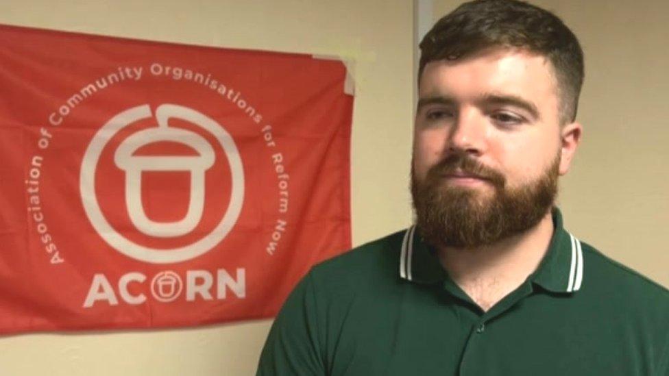 Mick Haworth in front of an Acorn flag