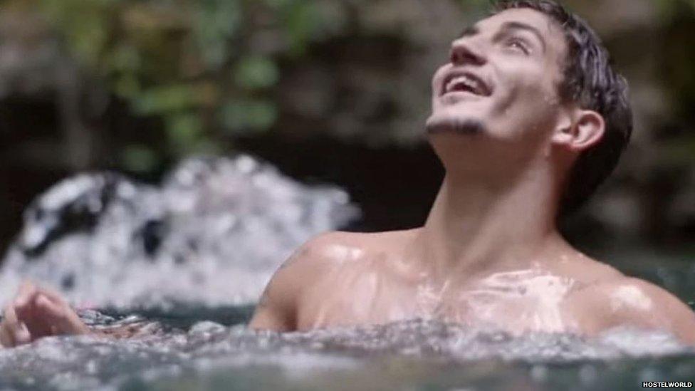 A man looks up from the water after jumping off cliffs