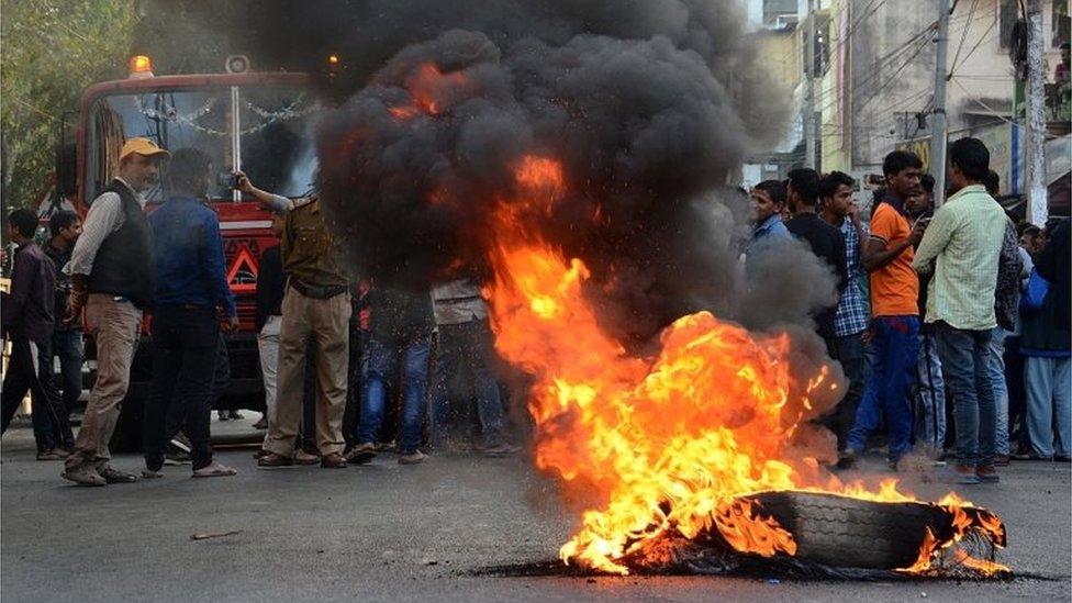 People protest by burning tyres on the street during the twelve hours Assam bandh or strike call, given by North East Student Organization (NESO) in protest against the Citizenship (Amendment) Bill (CAB