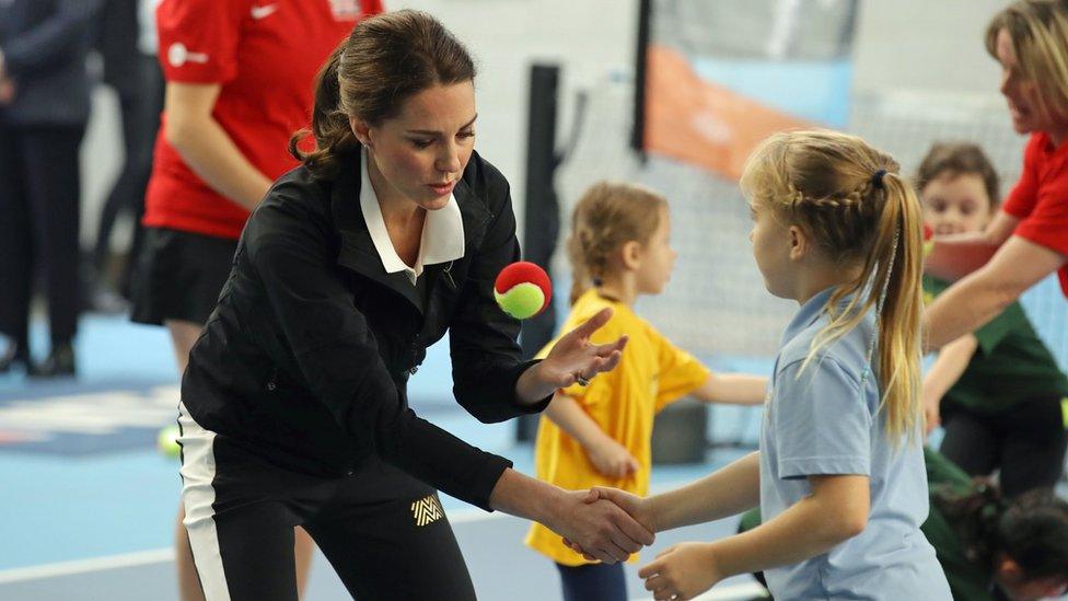 The Duchess of Cambridge throws a tennis ball with a girl