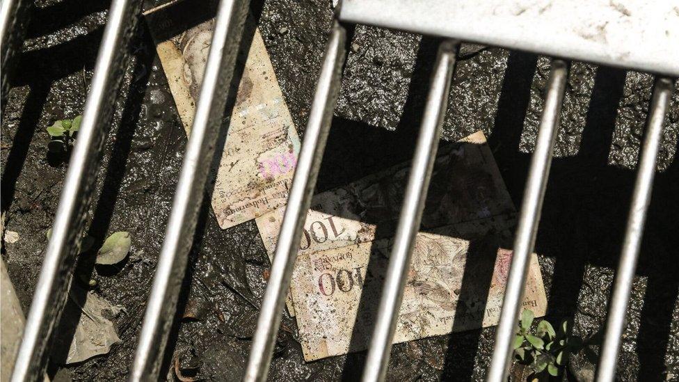 100-bolivar notes lie discarded in the gutter