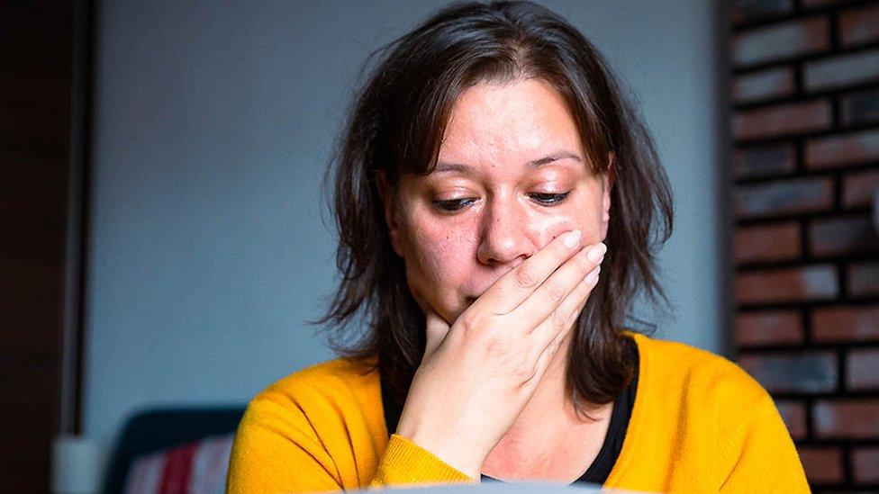 Anxious woman looks at bills