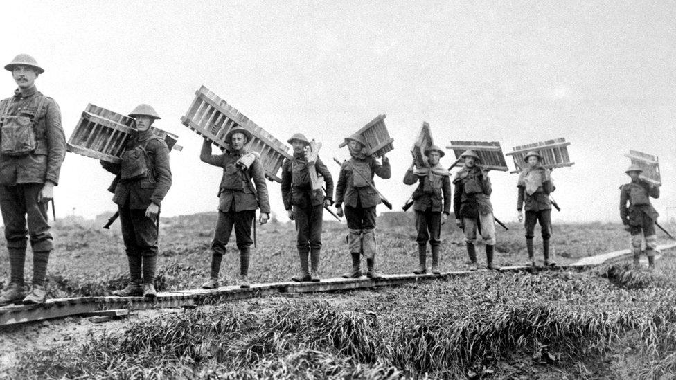 British troops taking a batch of duck-boards across marshy ground, during the Battle of the Somme