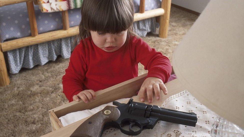 child reaching for gun