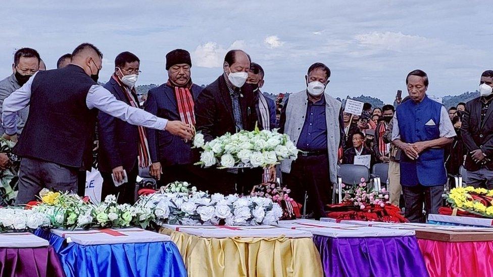 Neiphiu Rio, Chief Minister of the northeastern state of Nagaland, places a wreath on a coffin during a mass funeral of civilians who were mistakenly killed by security forces, in Mon district of Nagaland, India, December 6, 2021