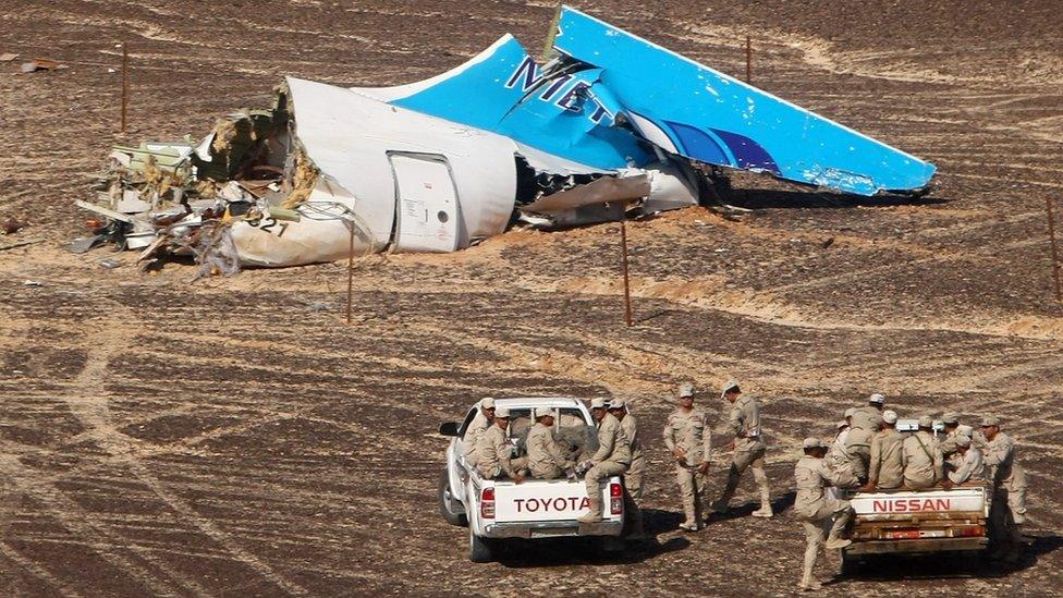 Egyptian Military on cars approach a plane's tail at the wreckage of a passenger jet bound for St. Petersburg in Russia that crashed in Hassana, Egypt, on Sunday, Nov. 1, 2015.