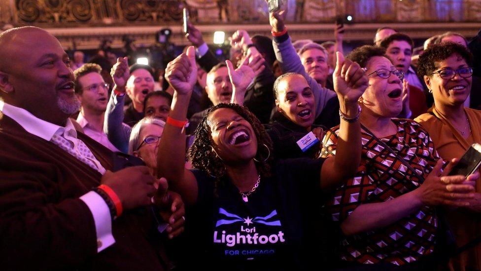 A woman celebrates Lori Lightfoot's victory