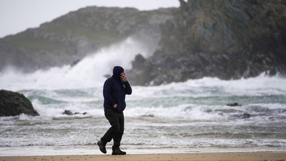 A man braves the winds of Hurricane Ophelia at Trearddur Bay in Holyhead