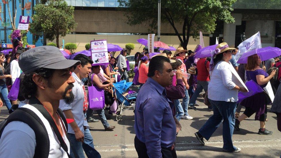 marchers pass by on a sunny street, April 2016