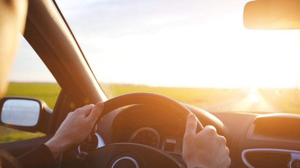 Person driving a car in the sun