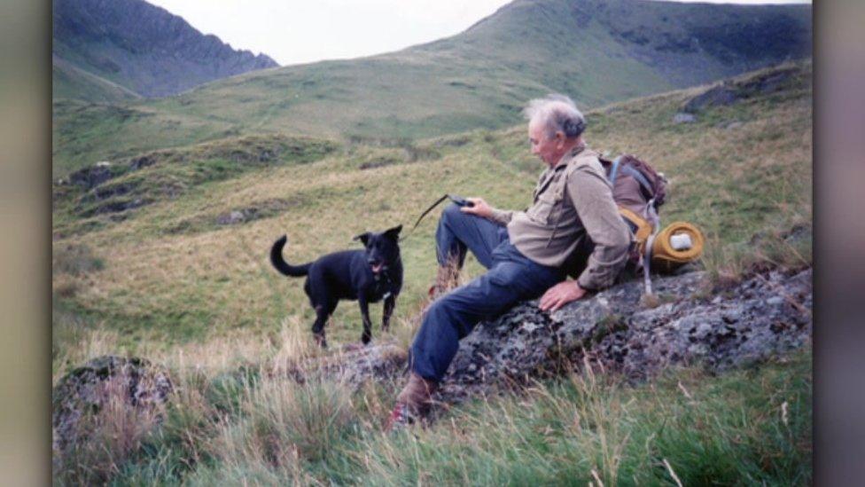 John Lenton and a black dog on a hill