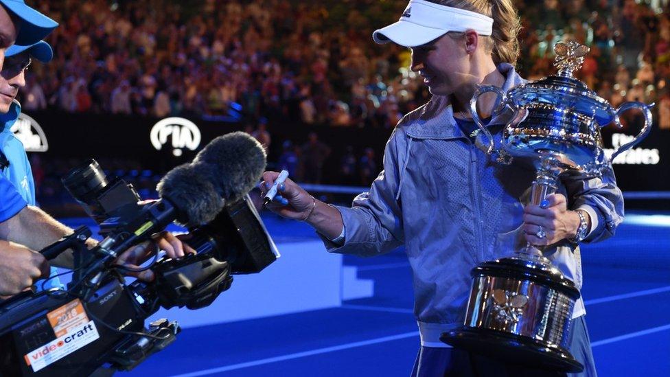 Caroline Wozniacki signs her autograph on a TV camera after winning the Australian Open tennis tournament in Melbourne on January 27, 2018.