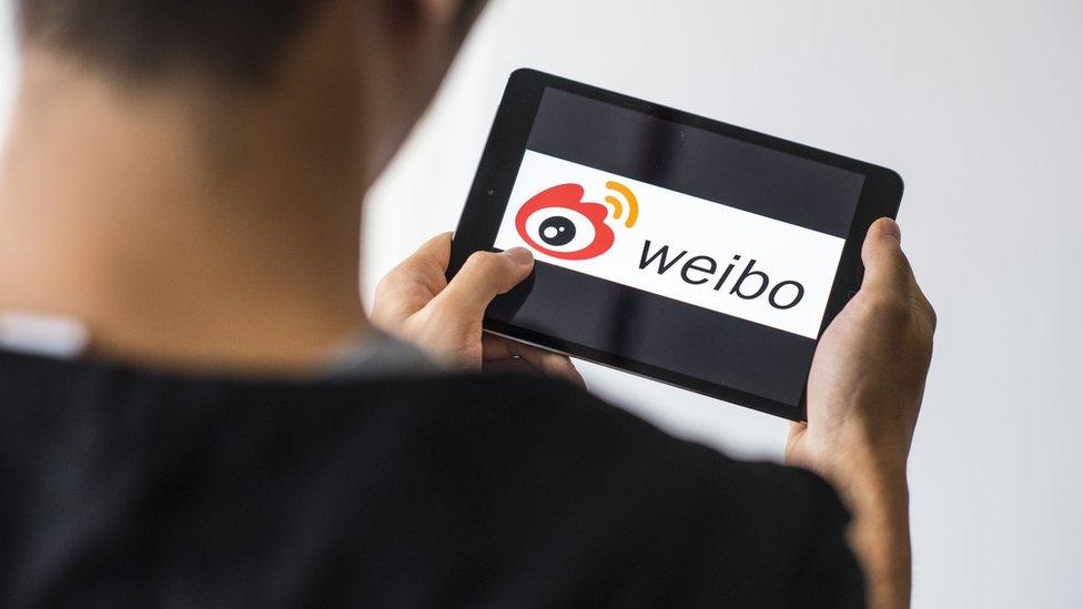 A man uses the Sino Weibo social media platform on a mobile device