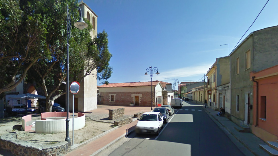 Picture shows a view of a main street and piazza in the Sardinian town of Zerfaliu.