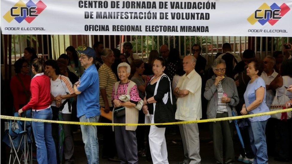 People stand in line outside a school during Venezuela's National Electoral Council (CNE) second phase of verifying signatures for a recall referendum against President Nicolas Maduro in Caracas, Venezuela June 20, 2016.