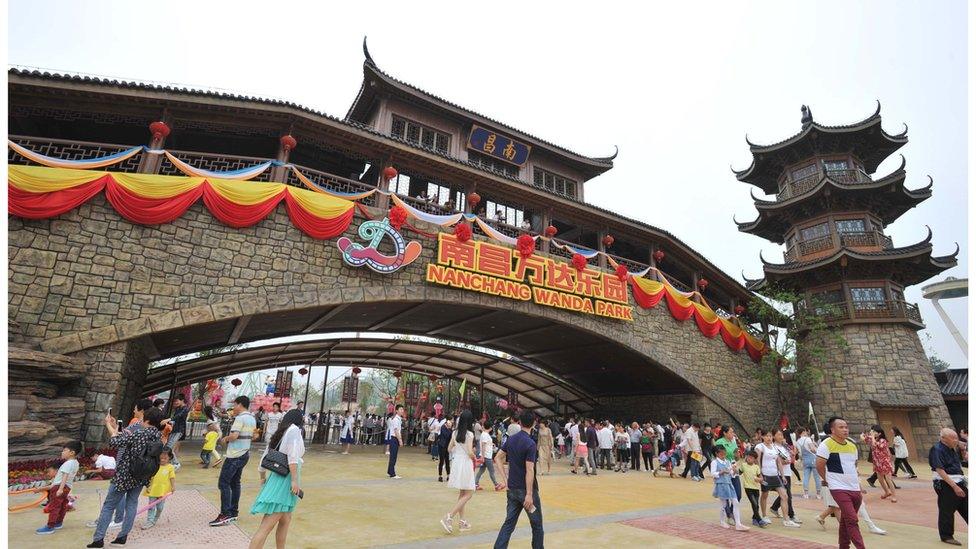 People walk under a Chinese-style bridge in the newly opened theme park Wanda City in Nanchang, on 28 May 2016.