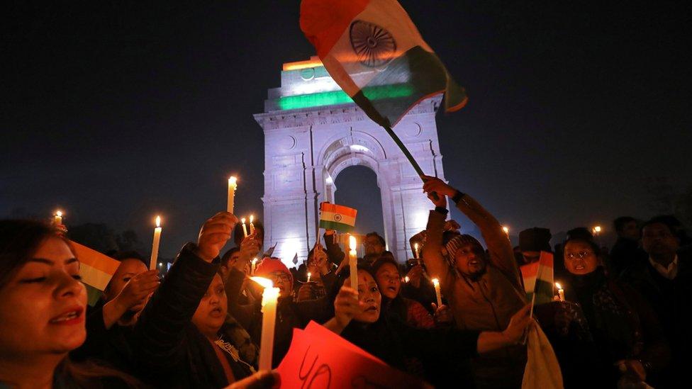 People attend a vigil in front of India Gate war memorial in Delhi, for personnel killed on Thursday