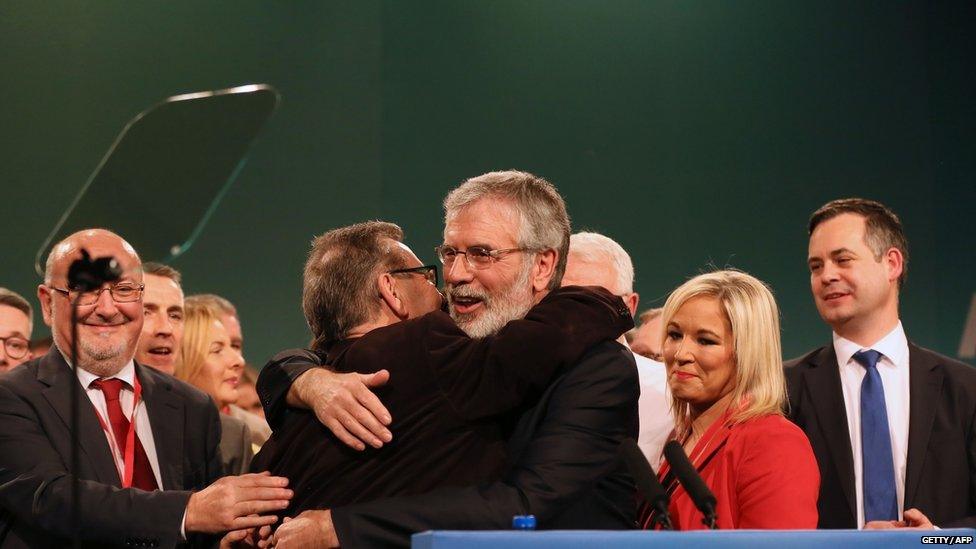 Gerry Adams surrounded by party colleagues after he announced he was standing down as Sinn Féin leader