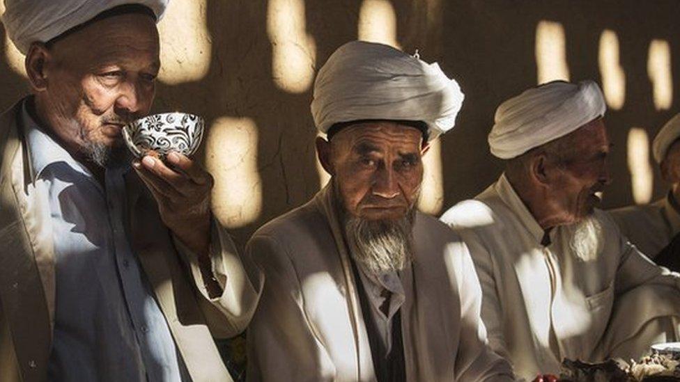 Uyghur men gather for a holiday meal during the Corban Festival on 13 September, 2016 in Turpan County, in the far western Xinjiang province, China