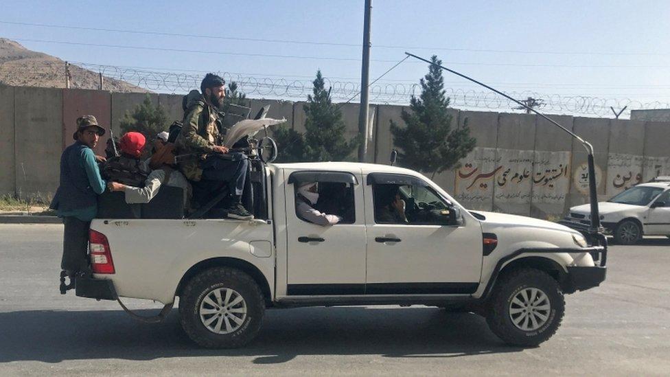 Fighters ride on a vehicle.