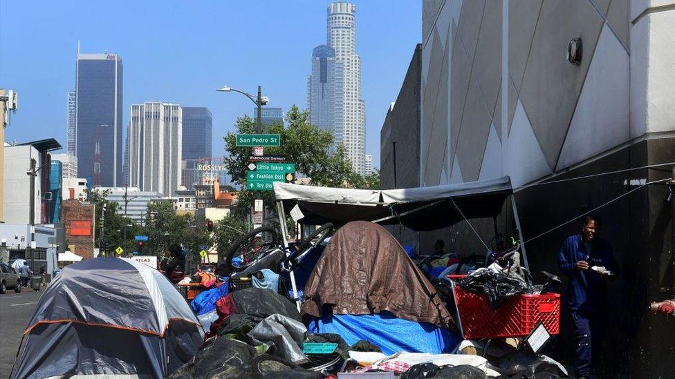 Tents with skyscrapers in the background in Los Angeles