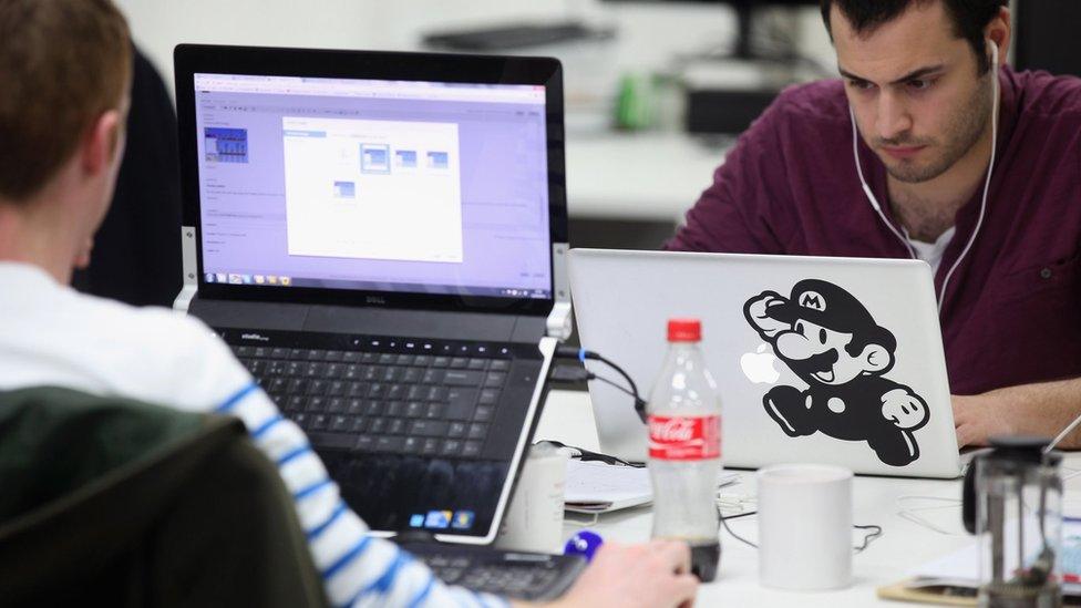 Two men work at a technology start-up in East London