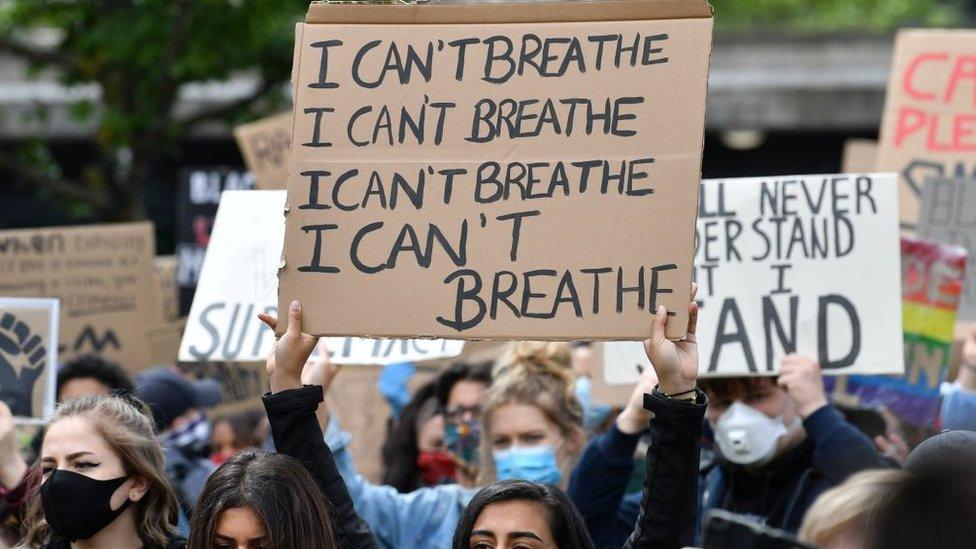 protestors-with-signs-in-Manchester.