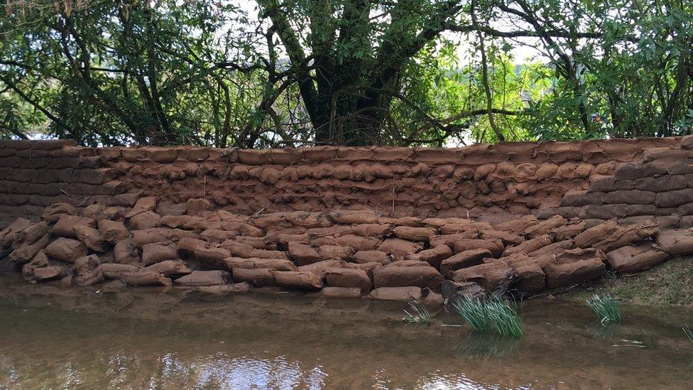 A breached sandbag wall