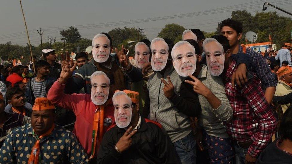 supporters of the Bharatiya Janata Party (BJP) pose wearing masks of PM Narendra Modi at an election rally in Ghaziabad on February 8, 2017