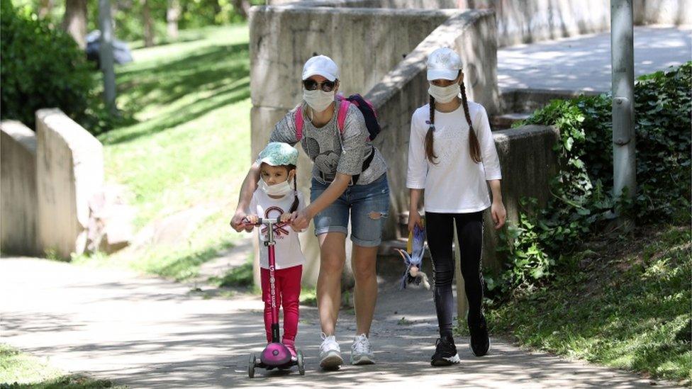 children and mother wearing masks