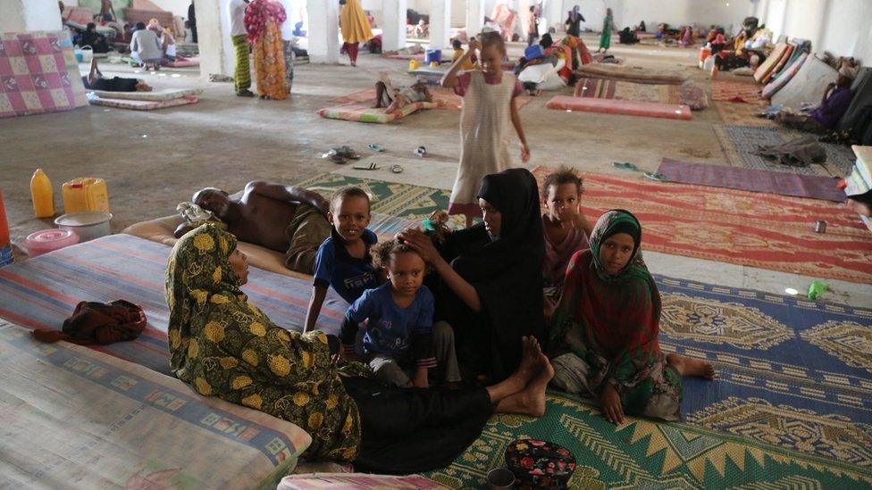 People sitting on a mattress at a transit centre, Bossasso, Somalia