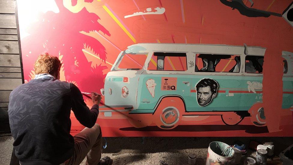 An artist draws an Austin-themed mural at the Australia House's opening night party