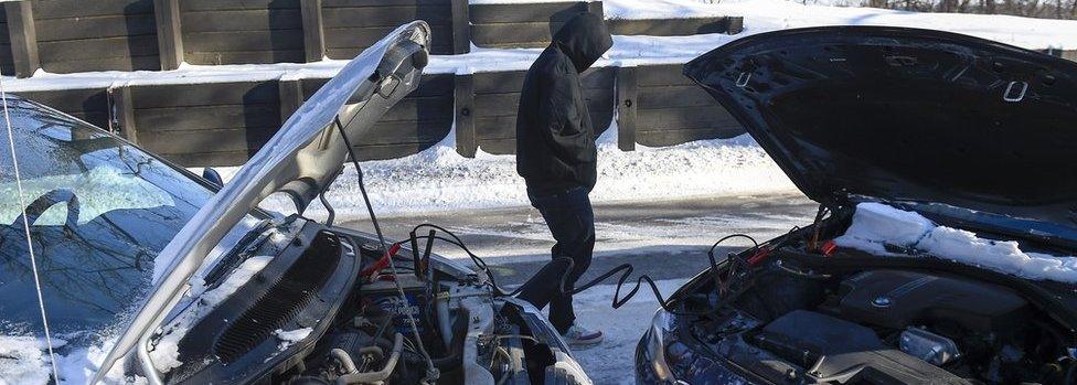 Roshewn Harington of St. Paul, MN tries to start his car in the -30 degrees Fahrenheit (-35 degrees Celsius) weather that has made travel difficult in Minneapolis