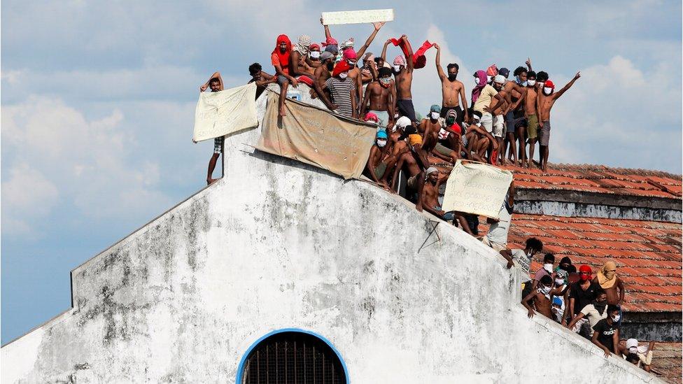 Inmates protest on the top of a prison building, in Colombo