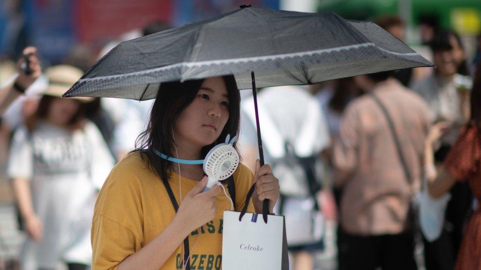 A woman fans herself in Tokyo.